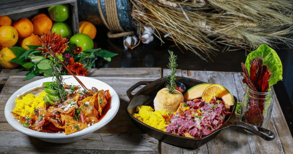 Comfort breakfast at Hash House A Go Go The LINQ featuring corned beef hash, scrambled eggs, chilaquiles, fresh fruit, and candied bacon.