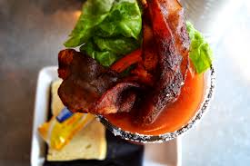 Bloody Mary cocktail garnished with bacon, pickles, and herbs at Hash House A Go Go, one of the signature cocktails served at The LINQ Las Vegas.