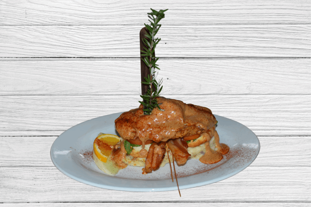 Close-up of Andy’s Sage Fried Chicken Benedict from Hash House A Go Go at The LINQ along the Las Vegas strip, topped with chipotle cream, bacon, spinach, and tomato on a biscuit
